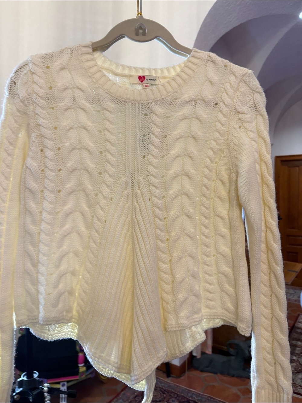 Cream color pointed sweater with black sash tie in back